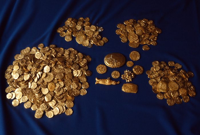 Caption 13- A remarkable display of hundreds of Spanish colonial escudos recovered from a 1715 Fleet site in 1988. In the center is a gold snuff box and jewelry from the same find. -1715 Fleet