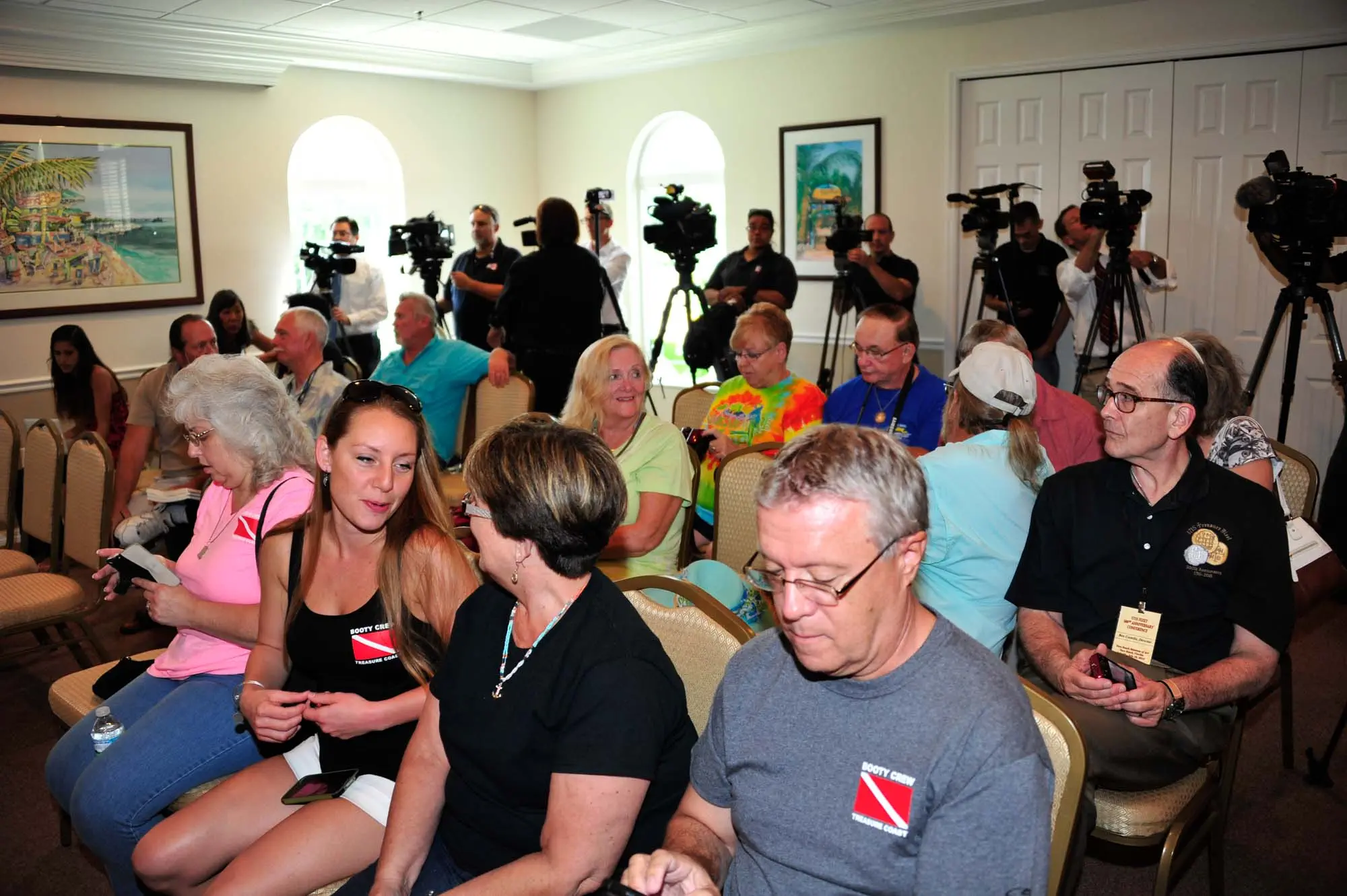 Camera men and interested observers wait for the news conference to begin